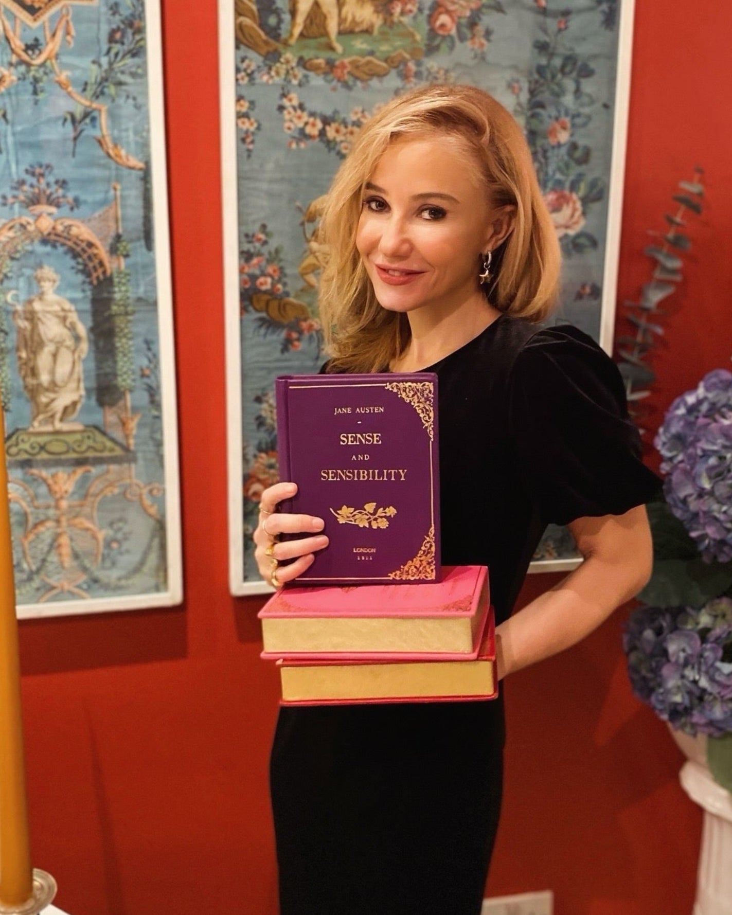 maria marigliano caracciolo, founder of By M. Design, holding her By M. Book clutches. 