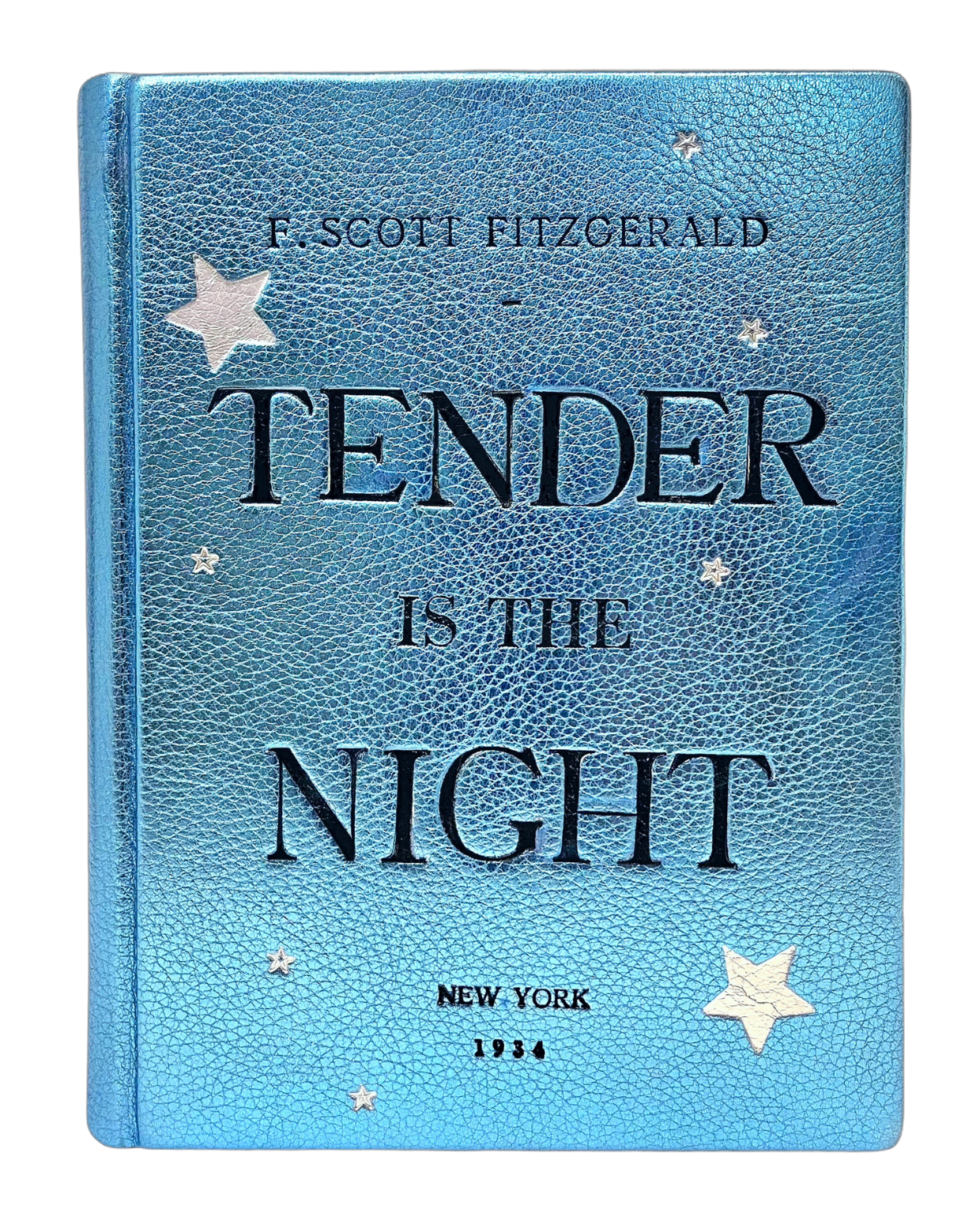 A metallic blue leather book clutch with the title 'TENDER IS THE NIGHT' embossed in black and silver, along with star patterns. By M. Design