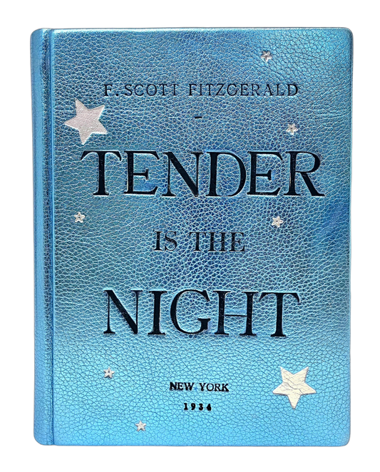 A metallic blue leather book clutch with the title 'TENDER IS THE NIGHT' embossed in black and silver, along with star patterns. By M. Design